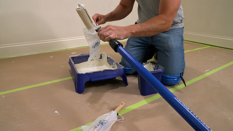 man putting a paint roller into the roller saver between uses